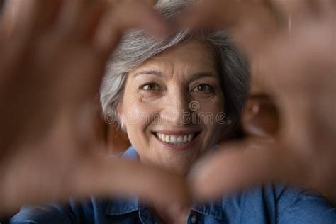Close Up Smiling Mature Grey Haired Woman Showing Heart Gesture Stock