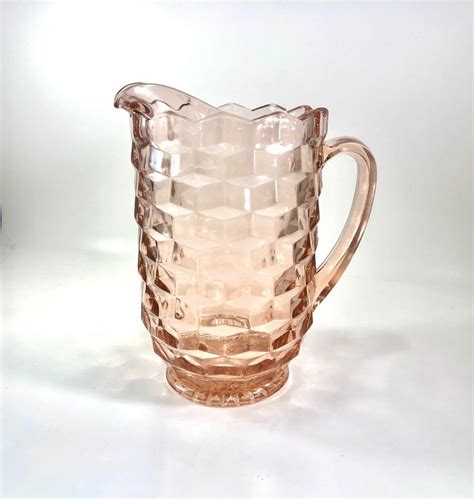 A Glass Pitcher Sitting On Top Of A White Table