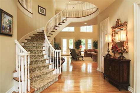 The Foyer With A Sweeping Circular Staircase Opens To