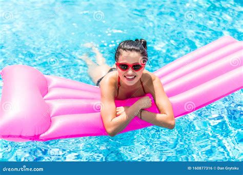 Young Pretty Woman In Sunglasses And Bikini Lying On Inflatable
