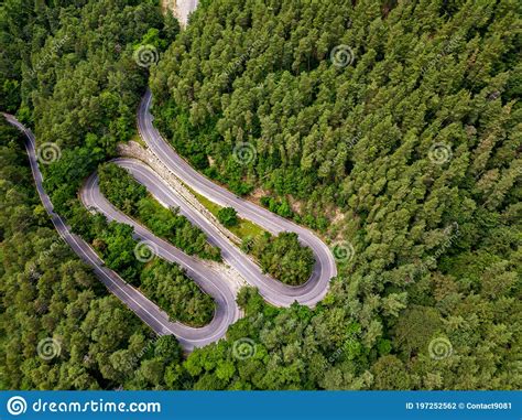 Winding Road Through The Forest From High Mountain Pass In Summer
