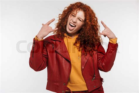 Portrait Of Crazy Redhead Woman 20s Wearing Leather Jacket Smiling And Sticking Out Her Tongue