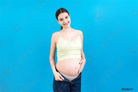 Naked Pregnant Womans Belly Wearing Opened Jeans At Colorful Background Stock Photo Crushpixel