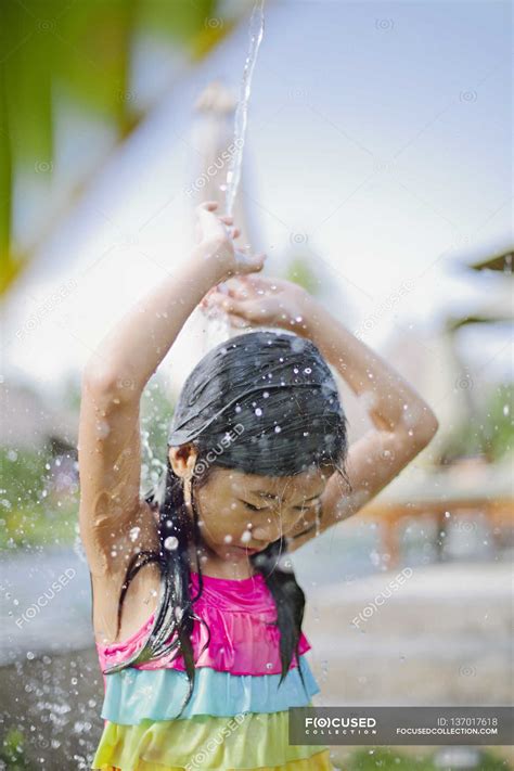 Girl Standing Under Shower Arms Raised Candid Stock Photo