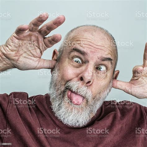 Playful Senior Adult Man Sticking Tongue Out Making Funny Face Stock