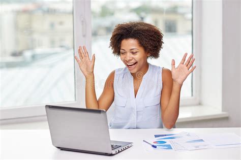 Happy African Woman With Laptop At Office Stock Photo
