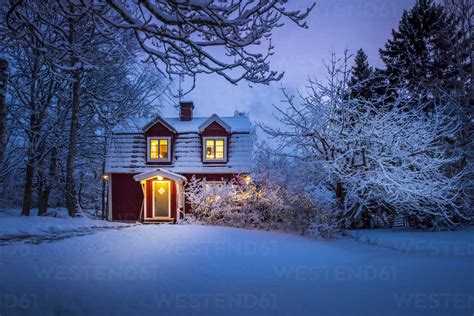 Wooden House In Snow At Dusk Stock Photo
