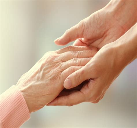 Old And Young Holding Hands On Light Background Closeup