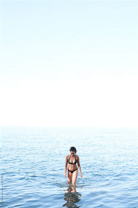 Slim Woman In Bikini Walking Out Of Water By Stocksy Contributor