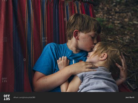 Brother Kissing His Sister S Forehead As They Cuddle In A Hammock Stock Photo Offset