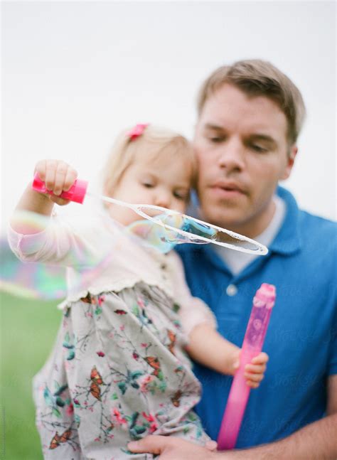 Father And Daughter Blowing Bubbles Del Colaborador De Stocksy Marta