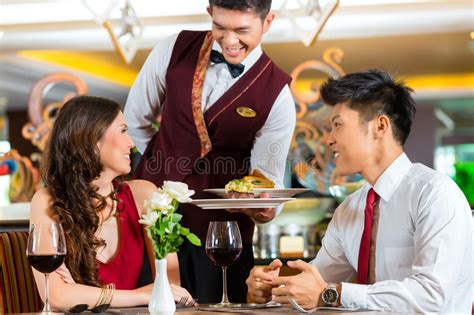 Chinese Waiter Serving Dinner In Elegant Restaurant Or Hotel Stock