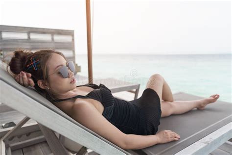 Mulher Asi Tica Que Senta Se Na Praia Do Bedchair Imagem De Stock Imagem De Exotic Povos
