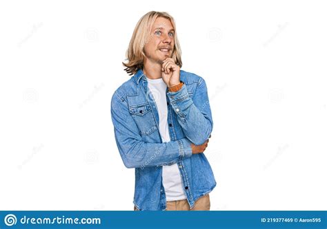 Caucasian Man With Blond Long Hair Wearing Casual Denim Jacket Looking