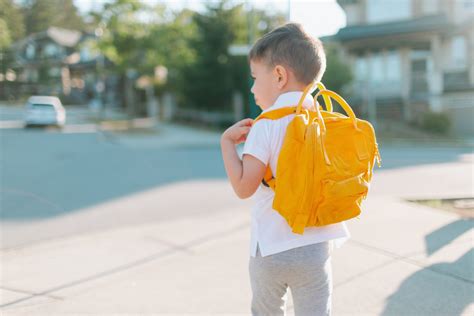 A Little Boy Walking To School With A Yellow Backpackt20lopgj7 Dr