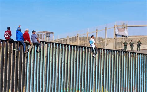 Migrantes Cruzan Valla En Frontera De Tijuana Con California N