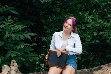 A Young Smiling Schoolgirl With Stylishly Dyed Hair With A Purple