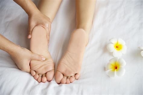 Woman Receiving Foot Massage Service From Masseuse Close Up At Hand And