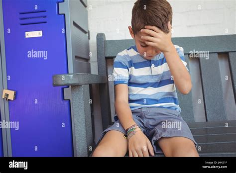 Sad Boy Sitting On Bench By Locker At School Stock Photo Alamy