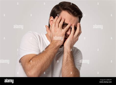 Scared Caucasian Man Cover Face Peeping Through Fingers Stock Photo Alamy