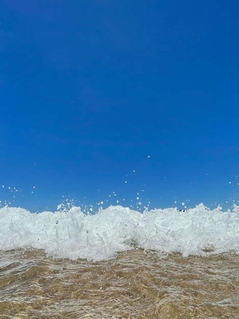 Ondas do mar na areia da praia no dia de verão céu azul bela paisagem Foto Premium