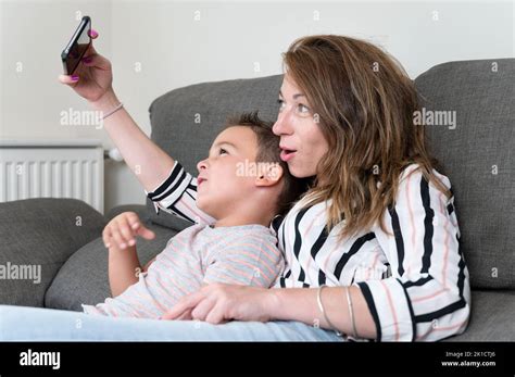 Cheerful Mother Holding Smart Phone Making Selfie With Her Little Son