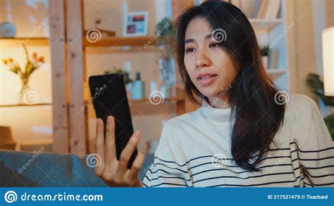 Sick Young Asian Lady Hold Medicine Sit On Couch Video Call With Phone Consult With Doctor At