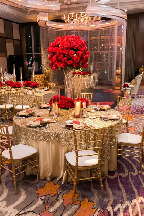 gold tables topped with tall red rose centerpieces las vegas wedding planner andrea eppolito