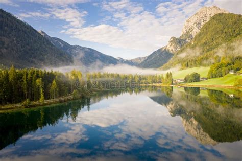 Wonderful View Of Lake Hintersee With Trees And Clouds Reflecting On