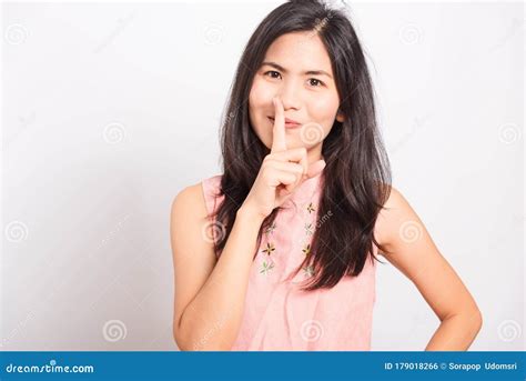 Young Woman Standing Making Hush Gesture With Fingers Stock Photo