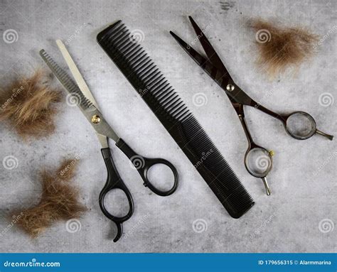 Hairdressing Two Scissors And A Comb With Cut Hair On A Concrete Gray