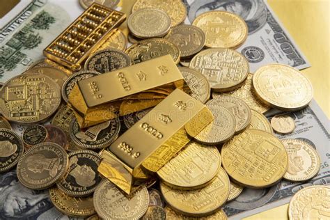Banknotes Golden Coins And Gold Bars Scattered On A Table Stock Photo