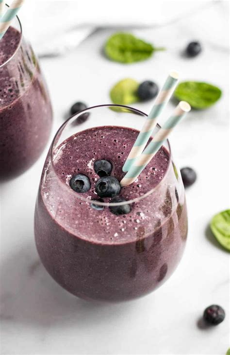 Two Glasses Filled With Blueberry Smoothie On Top Of A White Table Next
