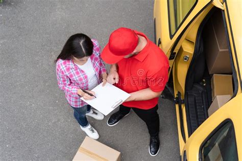 Woman Is Signing A Delivery Document From A Courier Top View Stock