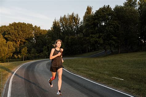 Fit Babe Woman Running Through City Park Road By Stocksy Contributor Alina Hvostikova Stocksy