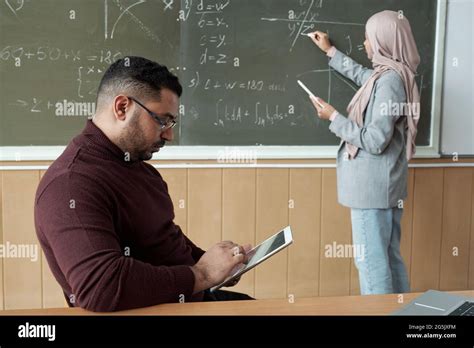 Junge Schülerin In Hijab Und Ihre Lehrerin An Der Tafel Stockfotografie