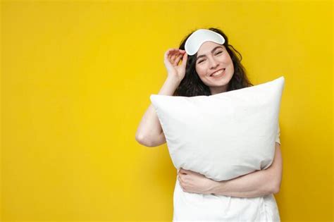 Premium Photo Woman In Sleep Mask Hugging White Soft Pillow On Yellow