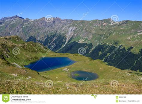 Two Mountain Lakes Surrounded With Green Alpine Meadows And Forest