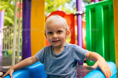 Little Child Boy Playing On Slide At Park Playground Stock Photo By