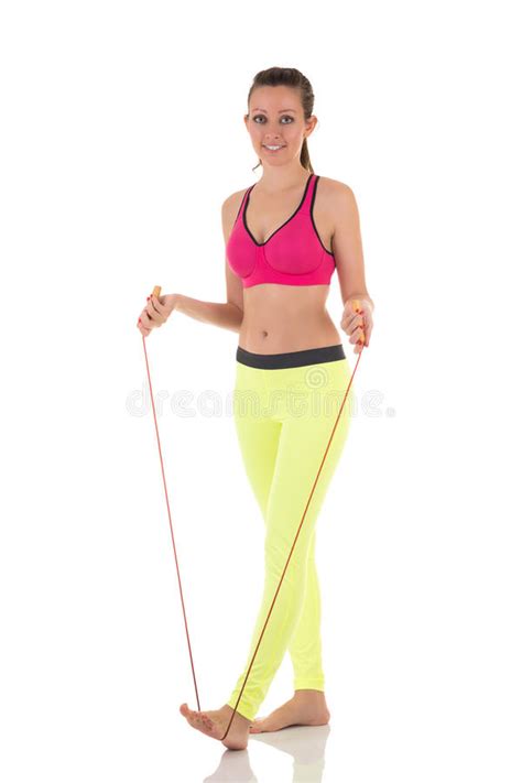 brunette woman wearing sports neon yellow bra and leggings stretching lateral trunk muscles with