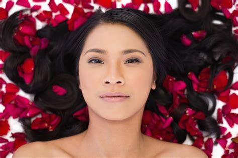 Premium Photo Sensual Dark Haired Model Lying In Rose Petals