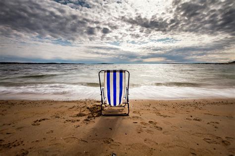 An Empty Deck Chair On A Beach Photograph By Runar Vestli