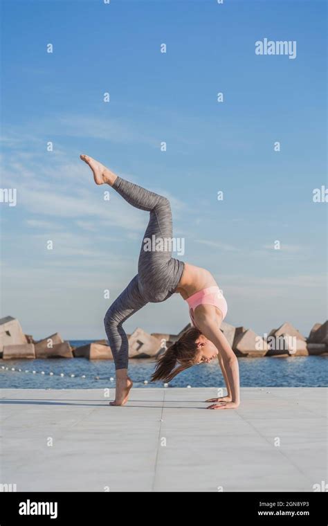 Woman Bending Backwards While Practicing Acroyoga On Boardwalk Stock