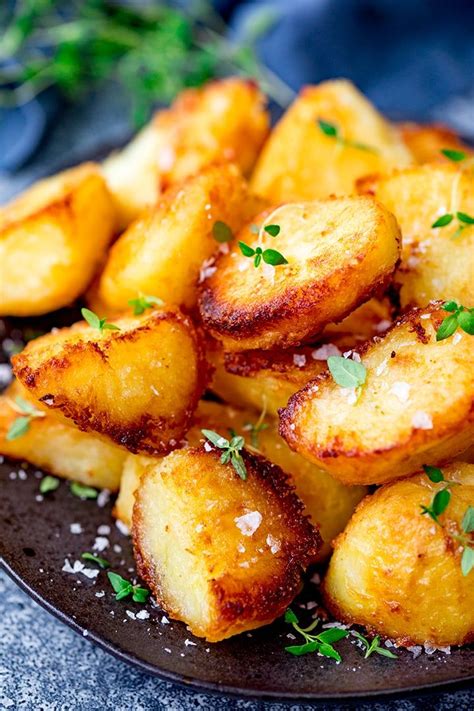 Fried Potatoes With Parmesan Cheese And Herbs On A Black Plate Ready