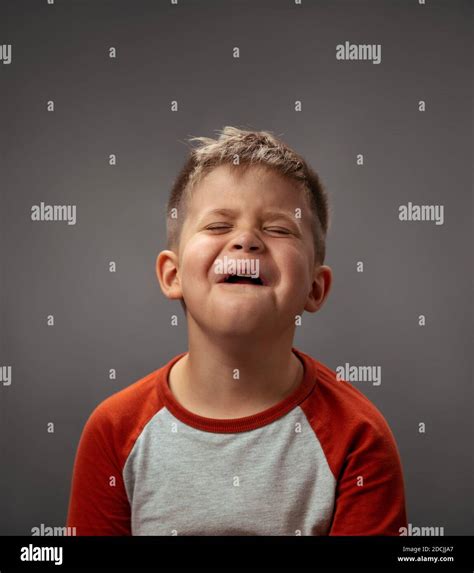 Portrait Of A Sad Pretending Cry Little Boy Isolated On Grey Background