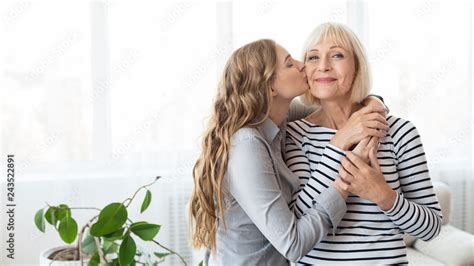 Young Daughter Kissing Senior Mother On The Cheek Foto De Stock Adobe Stock
