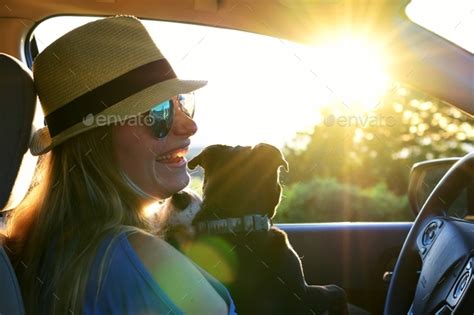 Woman Laughing While Watching A Sunset From Her Car On A Road Trip