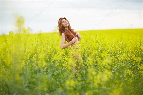 Chica desnuda de pie en el campo amarillo fotografía de stock nikolodion