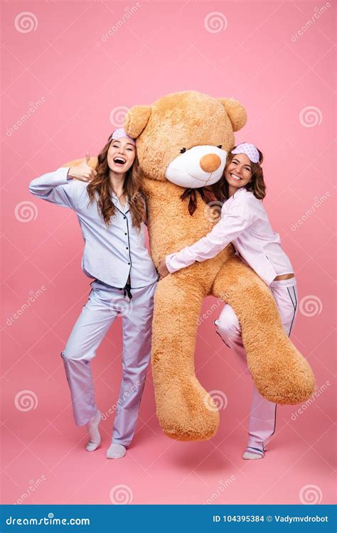 Friends Women In Pajamas With Teddy Bear Showing Thumbs Up Stock Photo