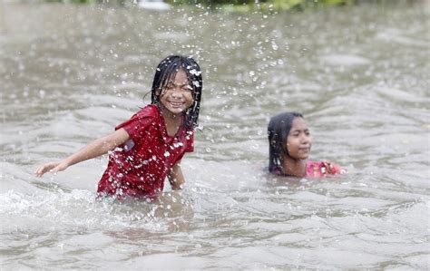 Children Play On A Flooded Street In Central Bago Town Around 100 Km
